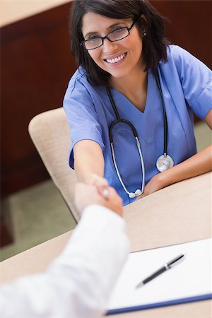 pictures of two nurses shaking hands - Happy nurse shaking doctors hand in a meeting Stock Photo - Budget Royalty-Free & Subscription, Code: 400-06874053