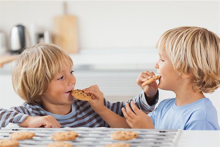 Brothers eating cookies together in the kitchen Stock Photo - Budget Royalty-Free & Subscription, Code: 400-06874090