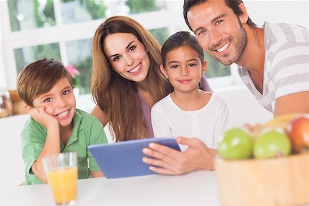 Happy family using a tablet pc in kitchen Stock Photo - Budget Royalty-Free & Subscription, Code: 400-06874204