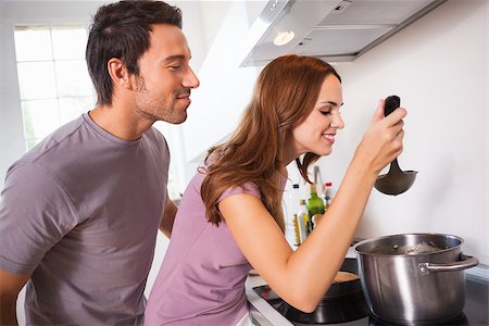 Couple tasting their dinner in kitchen Stock Photo - Budget Royalty-Free & Subscription, Code: 400-06874240