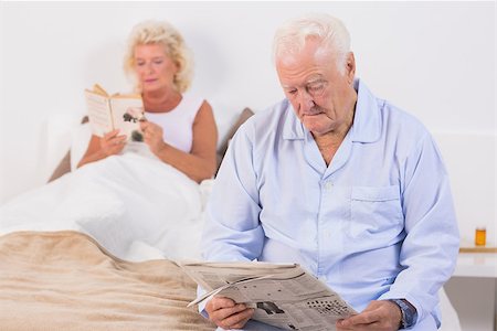 simsearch:400-06888132,k - Old couple reading on the bed in the bedroom Photographie de stock - Aubaine LD & Abonnement, Code: 400-06874416