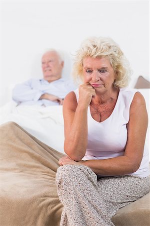 simsearch:400-06888132,k - Discouraged old woman sitting on the bed with old man in background Photographie de stock - Aubaine LD & Abonnement, Code: 400-06874427