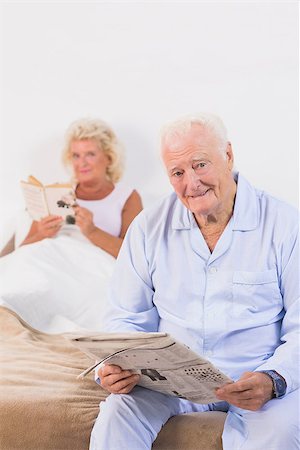 simsearch:400-06888132,k - Old persons looking at camera while reading on the bed Photographie de stock - Aubaine LD & Abonnement, Code: 400-06874420