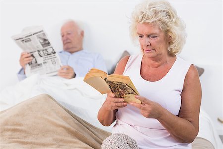 simsearch:400-06888132,k - Aged couple reading a book and newspaper on the bed Photographie de stock - Aubaine LD & Abonnement, Code: 400-06874422
