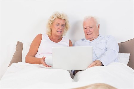 simsearch:400-06888132,k - Aged couple reading or using a tablet on the bed Photographie de stock - Aubaine LD & Abonnement, Code: 400-06874444