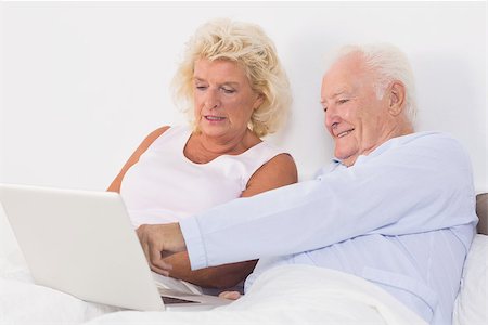 simsearch:400-06888132,k - Aged couple using a laptop on the bed Photographie de stock - Aubaine LD & Abonnement, Code: 400-06874445
