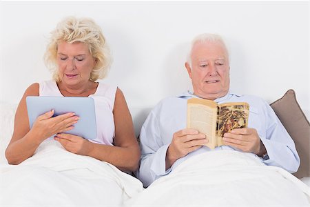 simsearch:400-06888132,k - Old couple reading and using a tablet pc in bed Photographie de stock - Aubaine LD & Abonnement, Code: 400-06874442