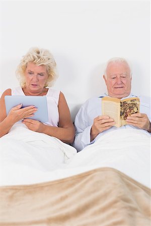 Old couple reading or using a digital tablet on the bed Stock Photo - Budget Royalty-Free & Subscription, Code: 400-06874443