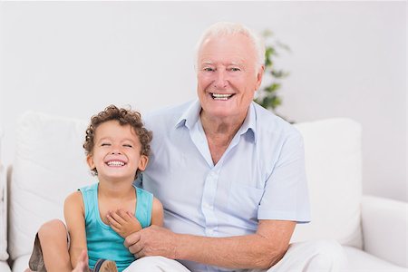 family sitting room sofa grandparents - Cheerful grandfather and grandson sitting on the sofa while smiling Stock Photo - Budget Royalty-Free & Subscription, Code: 400-06874495