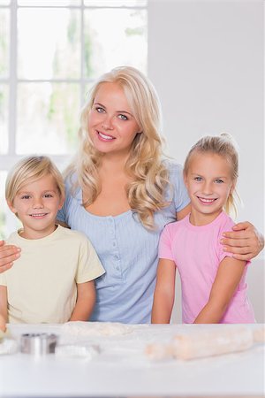 Blond esmiling family at the camera with baking things Stock Photo - Budget Royalty-Free & Subscription, Code: 400-06874575