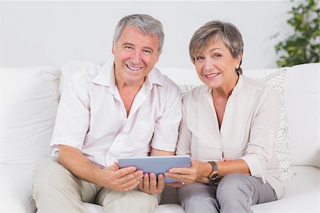 Old couple looking camera with tablet pc in their hands Stock Photo - Budget Royalty-Free & Subscription, Code: 400-06874615