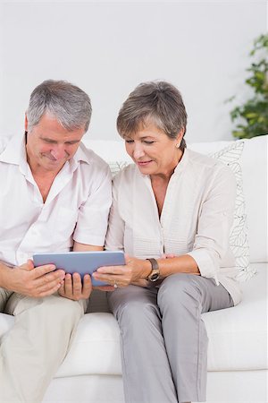 simsearch:400-06874653,k - Old couple looking tablet pc in their hands with smiling Photographie de stock - Aubaine LD & Abonnement, Code: 400-06874617