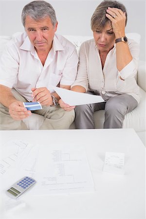 simsearch:400-06874653,k - Stressed couple calculating bills in sitting room Photographie de stock - Aubaine LD & Abonnement, Code: 400-06874618