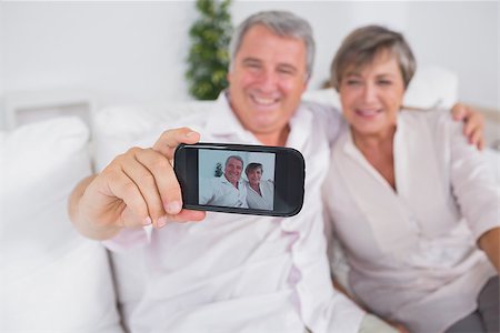 picture of woman with old mobile phone - Old man taking a photo of him and his wife with a smartphone Stock Photo - Budget Royalty-Free & Subscription, Code: 400-06874610