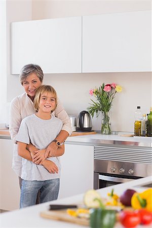 simsearch:400-06874653,k - Grandmother taking her grandson in her arms in kitchen Photographie de stock - Aubaine LD & Abonnement, Code: 400-06874665