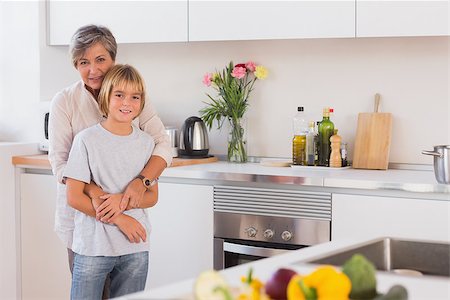 simsearch:400-06874653,k - Grandmother hugging her grandson in her arms in kitchen Photographie de stock - Aubaine LD & Abonnement, Code: 400-06874666