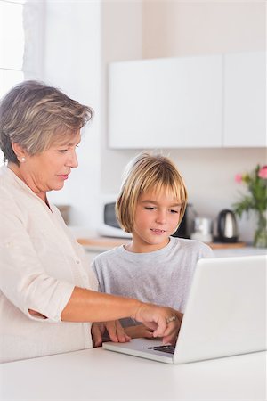 simsearch:400-06874653,k - Granny and grandson looking at laptop in kitchen Photographie de stock - Aubaine LD & Abonnement, Code: 400-06874673