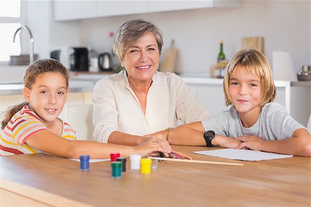 simsearch:400-06874653,k - Granny and her grandchildren looking at camera with smile in kitchen Photographie de stock - Aubaine LD & Abonnement, Code: 400-06874718