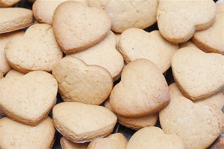 Lots of freshly baked heart shaped biscuits lying on top of each other Foto de stock - Super Valor sin royalties y Suscripción, Código: 400-06874860