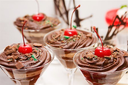 Glasses filled with chocolate mousse topped with a red cherry Foto de stock - Super Valor sin royalties y Suscripción, Código: 400-06874862