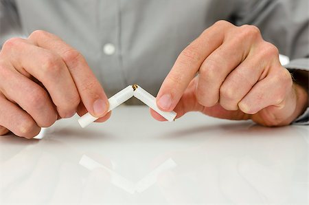 quitter - Front view of male hands breaking a cigarette. Concept of beating cigarette addiction. Photographie de stock - Aubaine LD & Abonnement, Code: 400-06875371