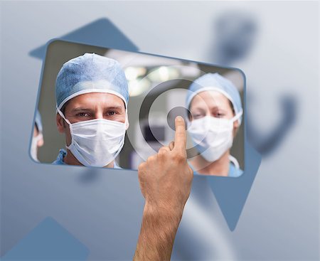 Hand selecting image of surgeons from blue digital interface Stock Photo - Budget Royalty-Free & Subscription, Code: 400-06875565