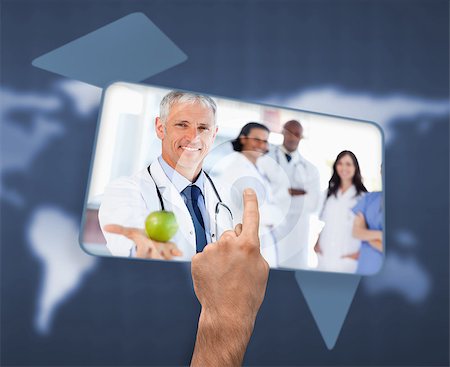 Hand selecting image of doctor holding apple on blue world map background Stock Photo - Budget Royalty-Free & Subscription, Code: 400-06875561