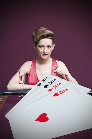 Attractive gambler betting on four aces in foreground Stock Photo - Budget Royalty-Free & Subscription, Code: 400-06875664