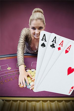 Blonde woman grabbing chips with digital hand of four aces at the foreground in the casino Stock Photo - Budget Royalty-Free & Subscription, Code: 400-06875672