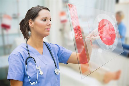 simsearch:400-06875952,k - Nurse touching screen showing red ECG data in hospital ward Stockbilder - Microstock & Abonnement, Bildnummer: 400-06875775