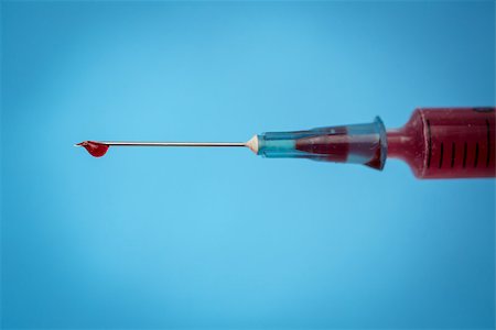 Drop of blood on needle of syringe filled with blood on blue background Stock Photo - Budget Royalty-Free & Subscription, Code: 400-06876212