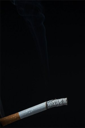 smoke in front of black - Burning cigarette on black background Stock Photo - Budget Royalty-Free & Subscription, Code: 400-06876294