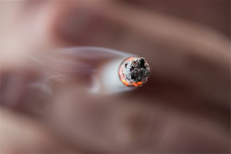 Focus on tip of burning cigarette being smoked by man Stock Photo - Budget Royalty-Free & Subscription, Code: 400-06876304