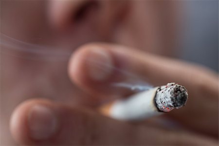 simsearch:400-06876304,k - Focus on top of burning cigarette being smoked by man Stockbilder - Microstock & Abonnement, Bildnummer: 400-06876305