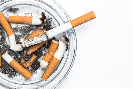 simsearch:400-06876304,k - Overhead of burning cigarette in ashtray with copy space on white background Stock Photo - Budget Royalty-Free & Subscription, Code: 400-06876311