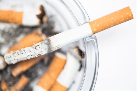 simsearch:400-06876304,k - Close up of cigarette in ashtray on white background Stockbilder - Microstock & Abonnement, Bildnummer: 400-06876312