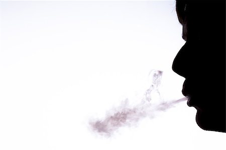simsearch:400-06876304,k - Silhouette of man blowing smoke with white copy space Stock Photo - Budget Royalty-Free & Subscription, Code: 400-06876371
