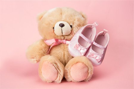 Fluffy teddy with pink ribbon and baby booties on pink background Stock Photo - Budget Royalty-Free & Subscription, Code: 400-06876462