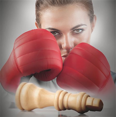 simsearch:400-06876600,k - Powerful female boxer with knocked white chess piece on chessboard Stock Photo - Budget Royalty-Free & Subscription, Code: 400-06876605
