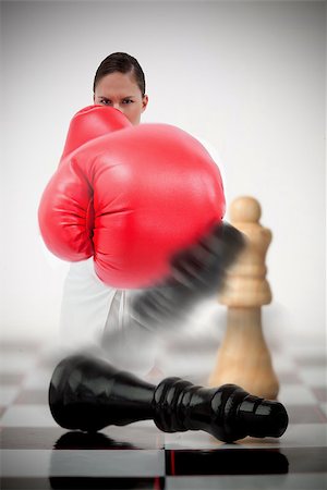 simsearch:400-06876600,k - Woman in boxing gloves knocking over chess pieces on chess board Stock Photo - Budget Royalty-Free & Subscription, Code: 400-06876600