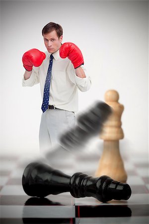simsearch:400-06876600,k - Businessman in boxing gloves knocking over chess pieces on a chessboard Stock Photo - Budget Royalty-Free & Subscription, Code: 400-06876601