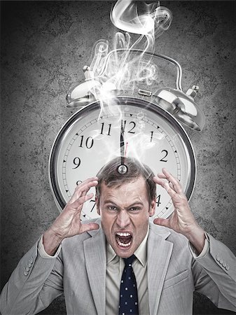 simsearch:400-06876570,k - Stressed businessman with a hot deadline on grey background Stock Photo - Budget Royalty-Free & Subscription, Code: 400-06876624