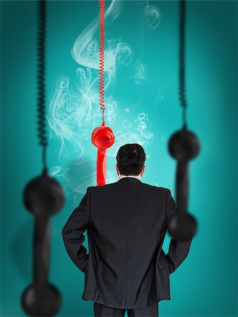 Businessman looking at smoking telephone receiver hanging against green background Stock Photo - Budget Royalty-Free & Subscription, Code: 400-06876686