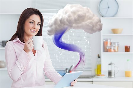 Smiling woman connecting to cloud computing with tablet at home in kitchen Stock Photo - Budget Royalty-Free & Subscription, Code: 400-06876729