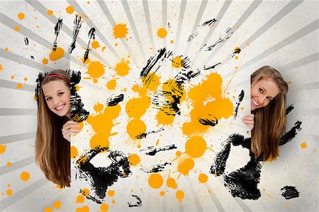 simsearch:400-06876781,k - Two pretty girls holding abstract art of yellow ink and black handprints Foto de stock - Royalty-Free Super Valor e Assinatura, Número: 400-06876734