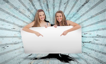 simsearch:400-06876787,k - Pretty girls pointing to copy space card on blue and grey pattern with black shards Foto de stock - Super Valor sin royalties y Suscripción, Código: 400-06876740