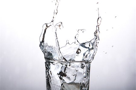 Close up on ice cube falling into glass of water on grey background Photographie de stock - Aubaine LD & Abonnement, Code: 400-06876798