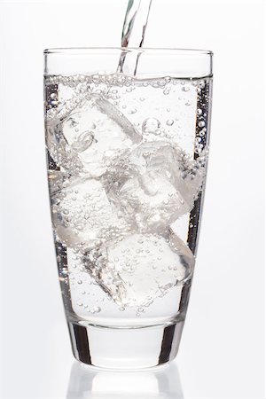 simsearch:400-06877048,k - Close up on sparkling water filling a glass on white background Foto de stock - Royalty-Free Super Valor e Assinatura, Número: 400-06876816