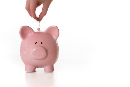 Hand putting coin into piggy bank with copy space on white background Stock Photo - Budget Royalty-Free & Subscription, Code: 400-06877165