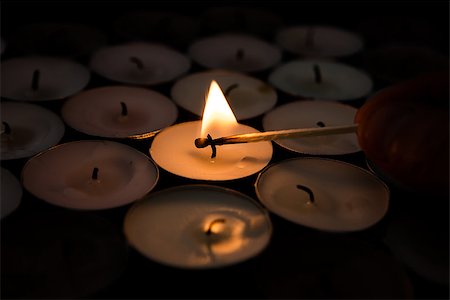 Match lighting tea light candle with others unlit Stockbilder - Microstock & Abonnement, Bildnummer: 400-06877249
